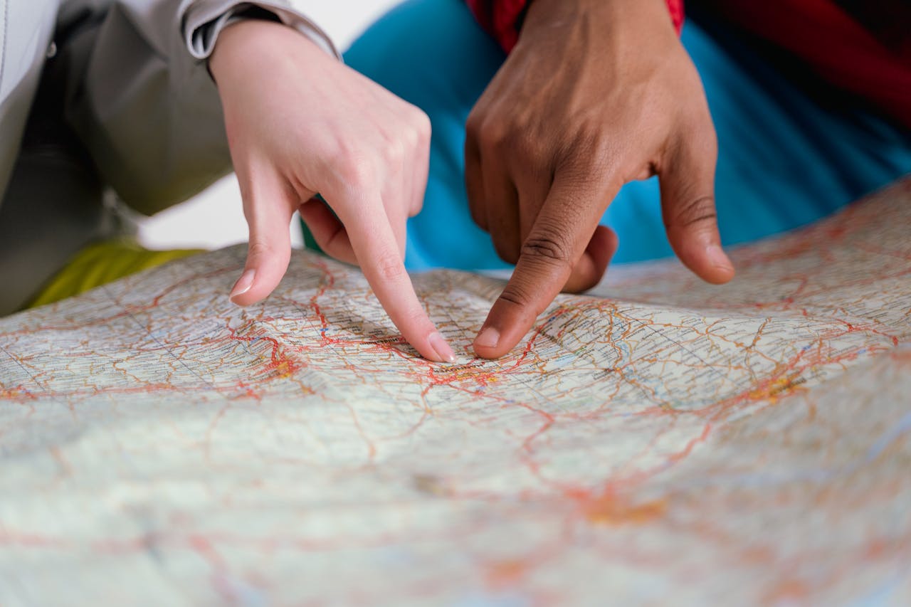 Two hands point to a location on a roadmap.